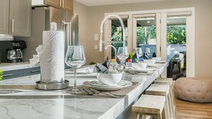 A modern kitchen with marble countertops, a built-in oven, and a large window offering a view of greenery. - Mountain Luxury In Old Town Spa - Walk To Main 440 3 Bedroom Home (Park City)