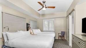 A hotel room with two beds, a ceiling fan, a window with blinds, a chair, a TV, and a dresser. - Marriott 2-bedroom villa with AC, fitness room in welcoming Hilton Head Island (Hilton Head Island)
