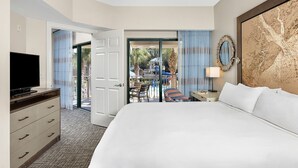 A hotel room with a large bed, a television, a ceiling fan, and a view of the outdoor pool area. - Marriott 2-bedroom villa with AC, fitness room in welcoming Hilton Head Island (Hilton Head Island)