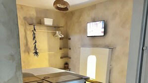 A modern kitchen with a dining area, featuring a white table, chairs, and a hanging light fixture. - Monet apartment-studio. Tranquility, style and location.  (Santa Marta)
