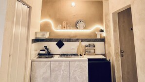 A compact kitchen with a gas stove, a sink, and a countertop. - Monet apartment-studio. Tranquility, style and location.  (Santa Marta)