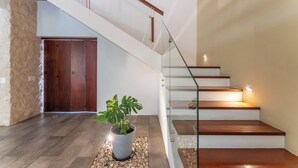 A modern staircase with wooden steps and glass railings, leading to a second floor. - Villa Tres Delfines Private Pool And Family Fun Puerto Aventuras (Puerto Aventuras)