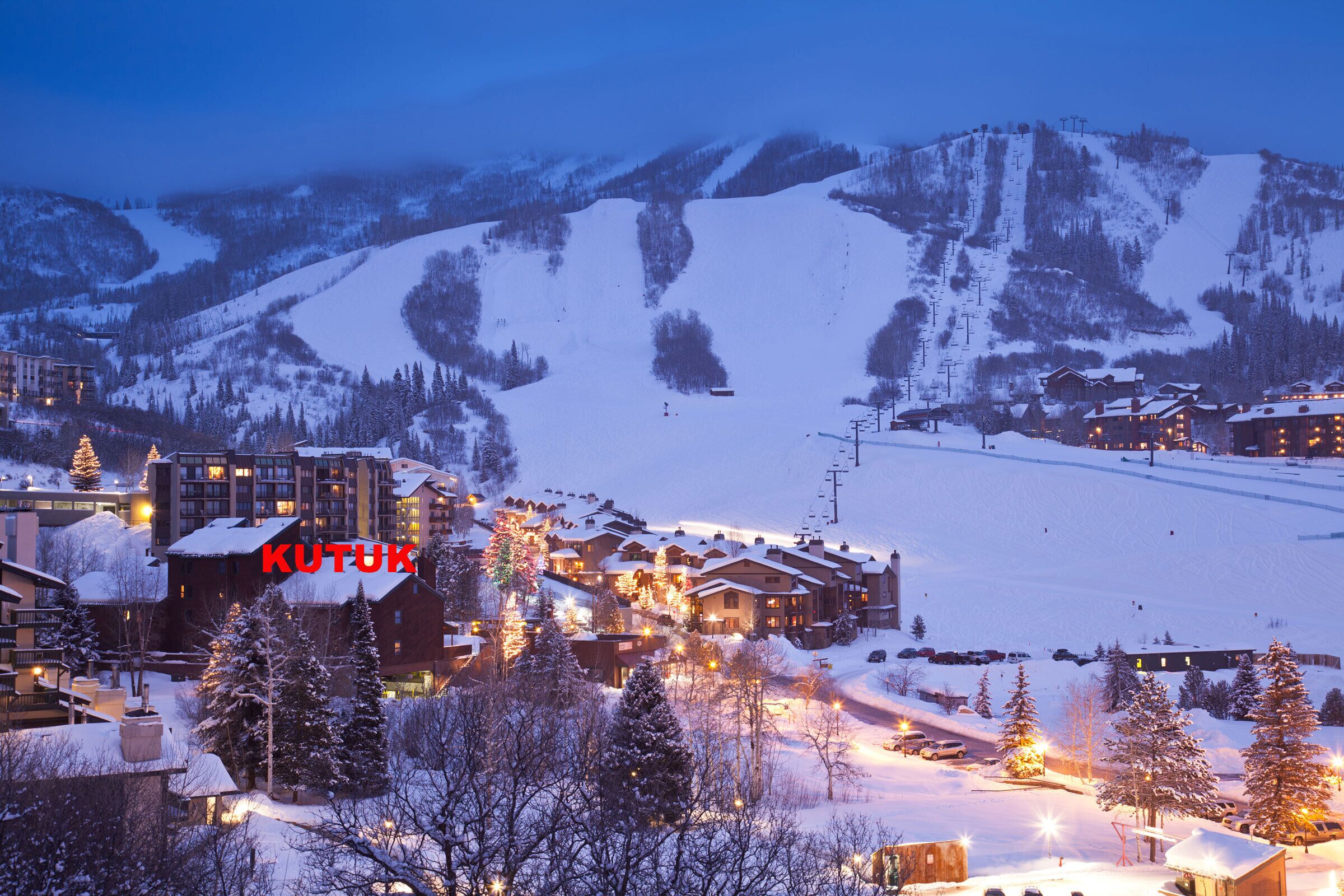 Un pueblo cubierto de nieve con edificios y pistas de esquí.