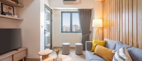 Suite familiar, vistes a la ciutat | Sala d'estar | Televisor intel·ligent de 32 polzades amb canals per cable