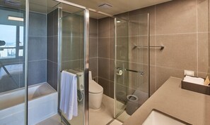 A modern bathroom with a glass-enclosed shower, a toilet, and a sink.