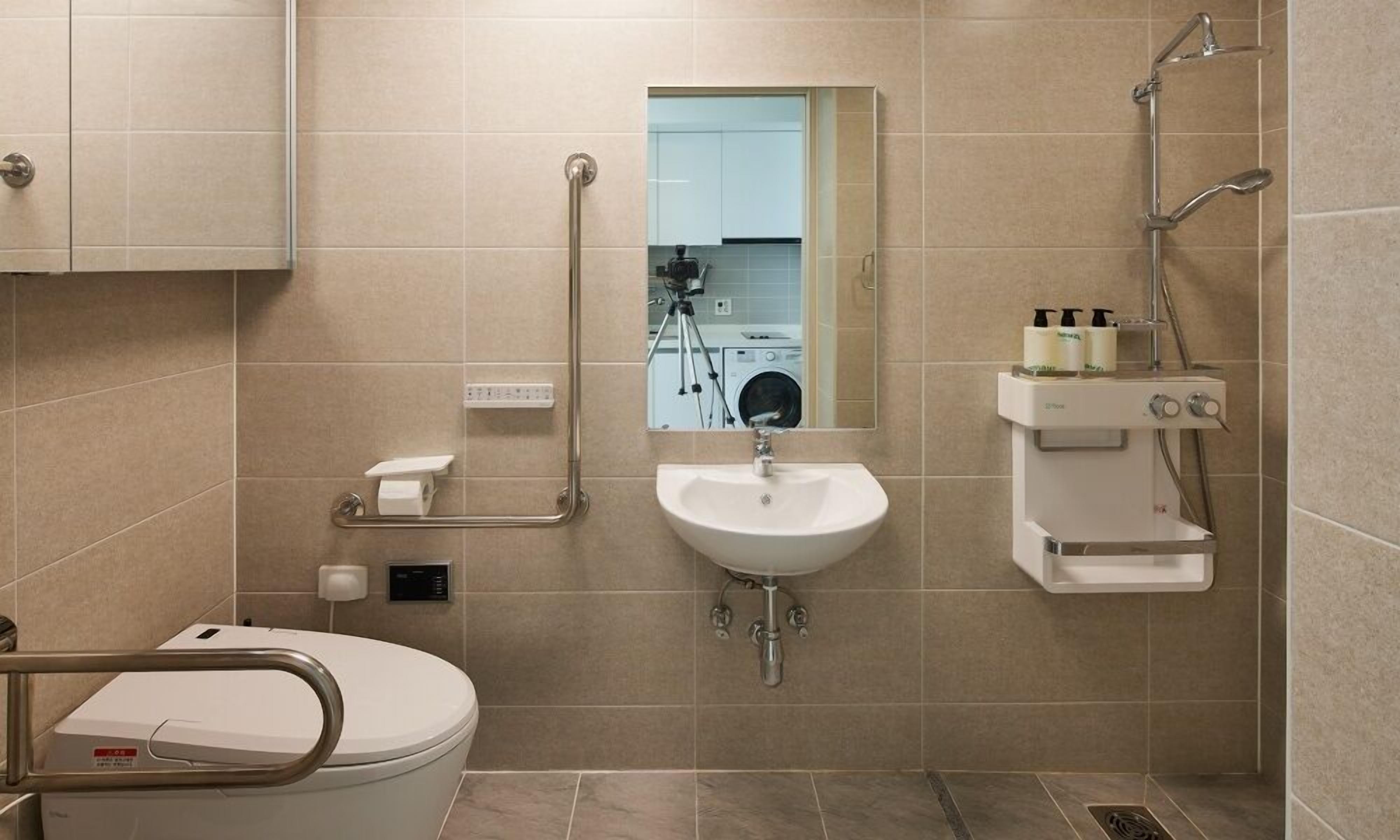 A modern bathroom with a toilet, sink, and shower.