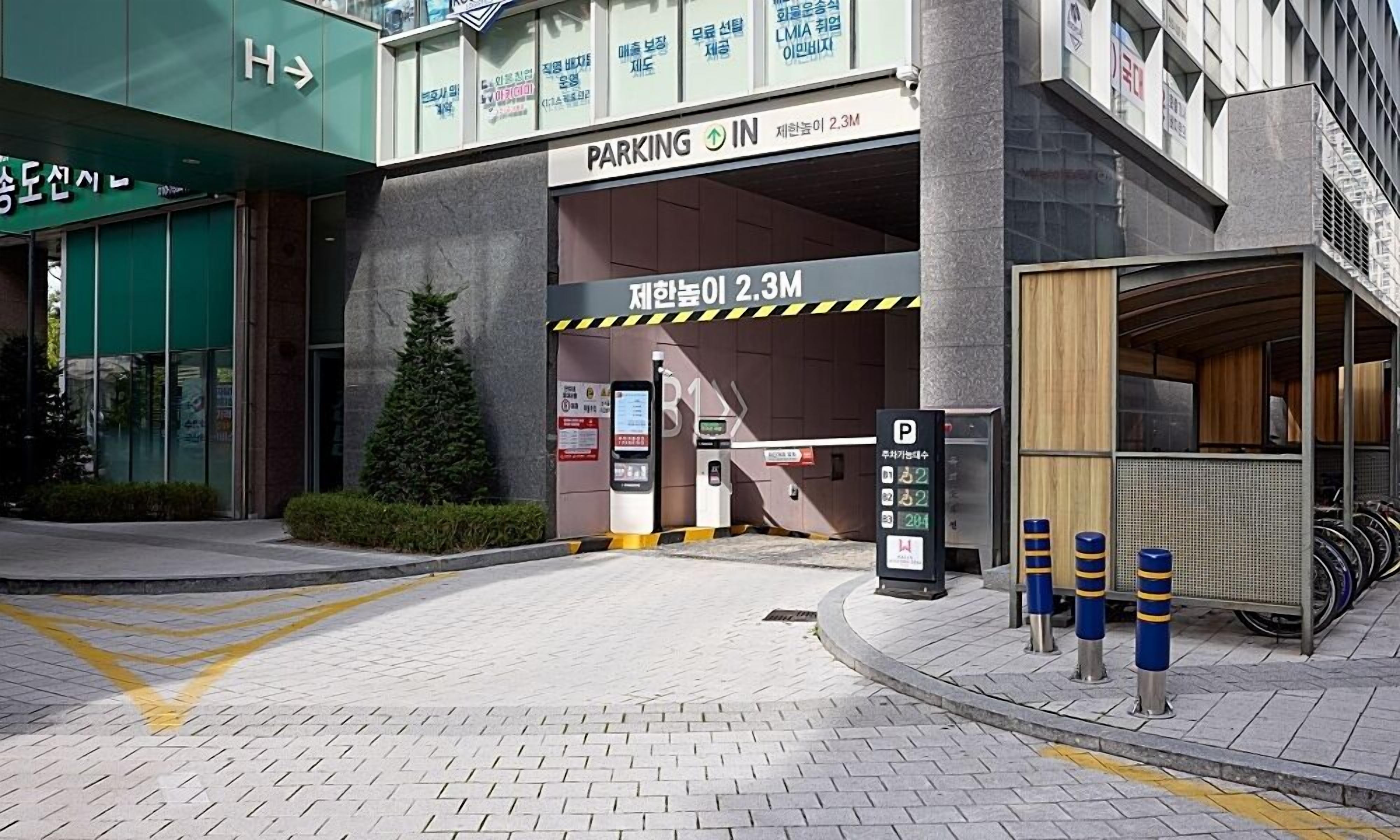 A parking garage entrance with a sign indicating a height limit of 2.3 meters.