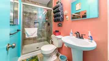 Ein Badezimmer mit Duschkabine, Toilette und Waschbecken.