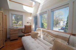 Um quarto com cama beliche, uma escrivaninha com cadeira e um sofá.