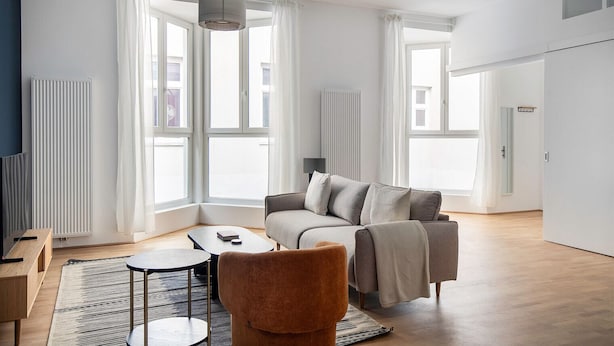 En moderne stue med sofa, lænestol, sofabord og tv-møbel.