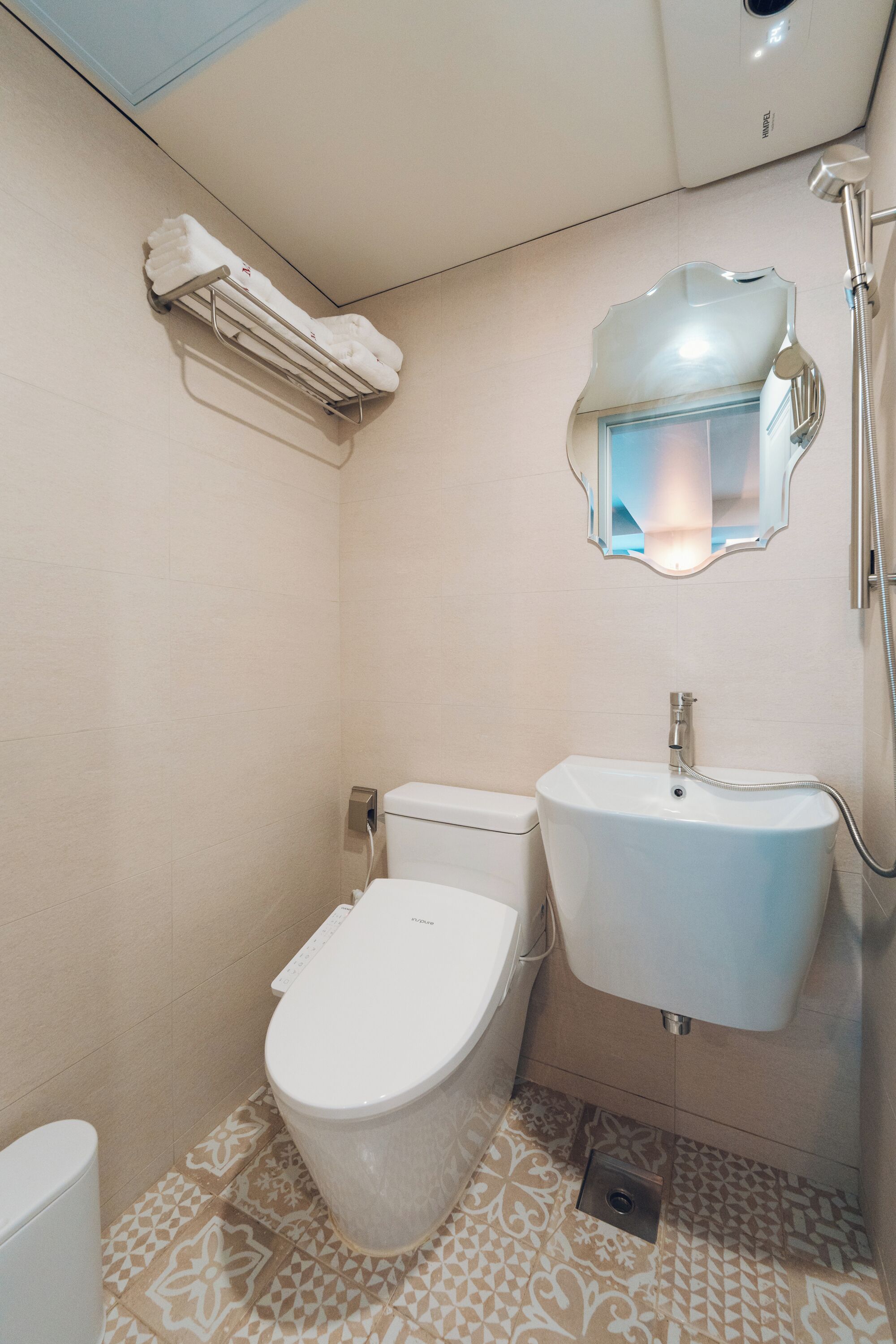 A bathroom with a toilet, sink, and shower.