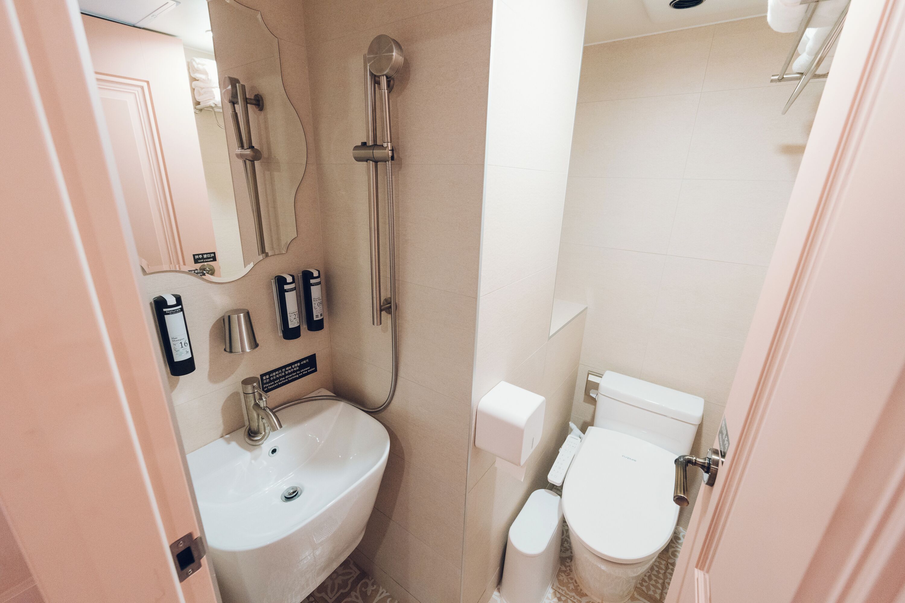 A compact bathroom with a sink, toilet, and shower.