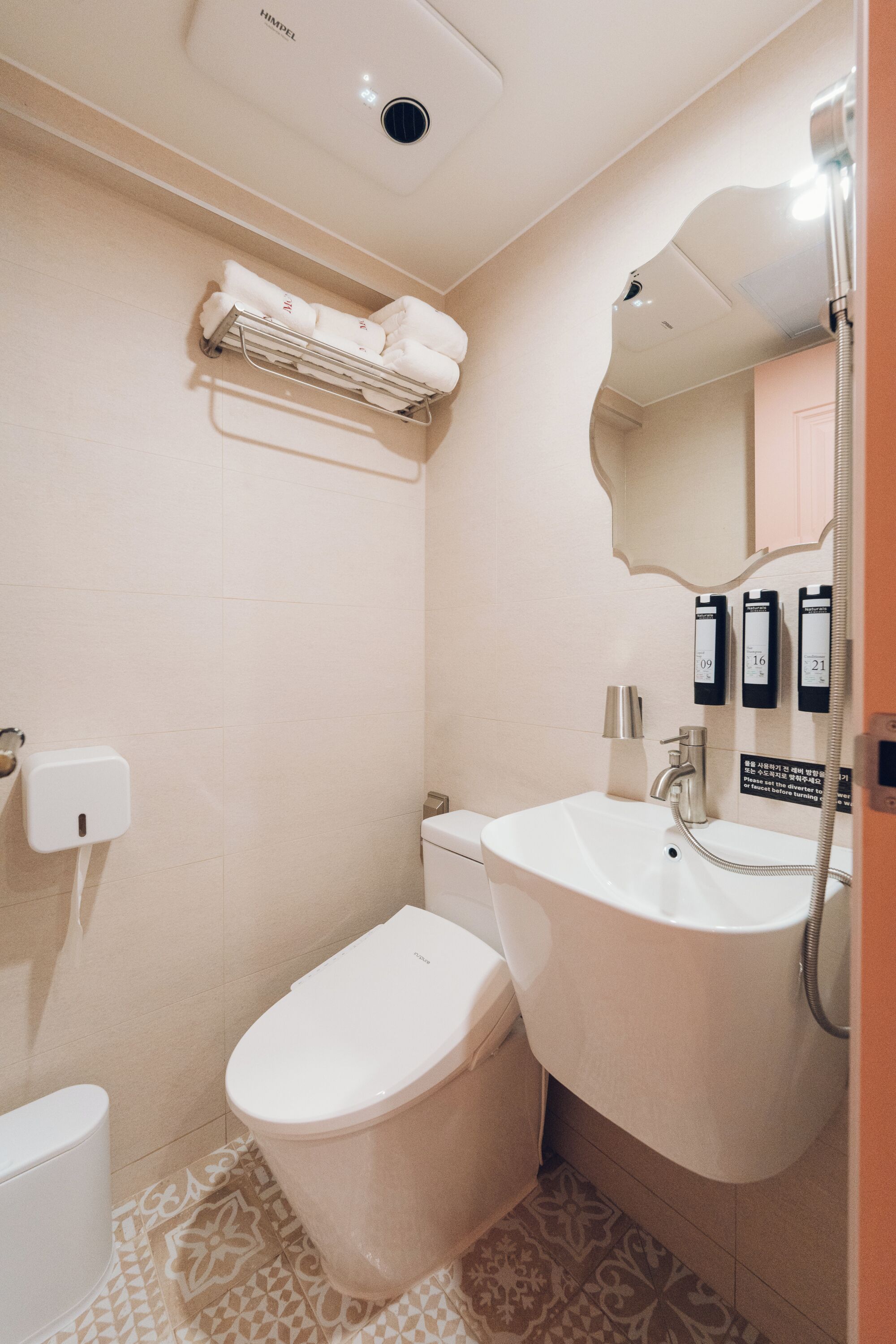 A bathroom with a toilet, sink, and towel rack.