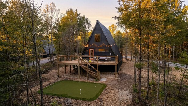 A cabin with a wooden deck and a small lawn area. - Golf Lovers 2-bedroom A-Frame Cabin by Big Cedar Golf (Omaha)