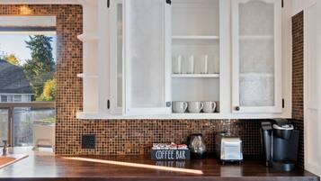 A kitchen with a coffee bar, a coffee maker, and a toaster.