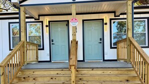 A wooden staircase leading to a house with two doors, one marked with an 'A' and the other with a 'B'. A 'No Trespassing' sign is visible on the right.