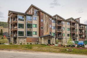 A multi-story residential building with balconies, large windows, and a stone facade. - 305 Brightwood At Keystone 2 Bedroom Condo (Keystone)