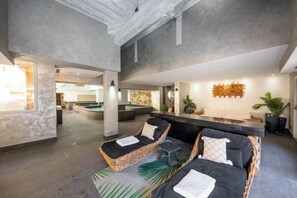 A spacious indoor area with a pool, seating area, and a reception desk. - Hotel la Chaudanne (Meribel)