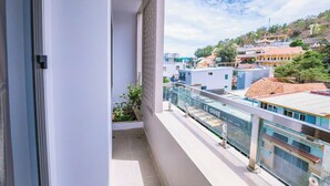 Een balkon met uitzicht op een stadsbeeld, inclusief gebouwen met een mix van moderne en traditionele architectuur.