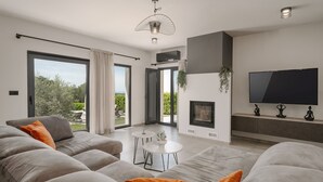En moderne stue med sofa, sofabord og et fladskærms-tv.