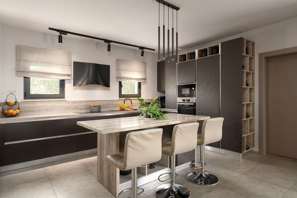 A modern kitchen with a central island, bar stools, built-in appliances, and a TV mounted on the wall.