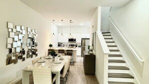 A modern kitchen with white cabinets, stainless steel appliances, and a central island.