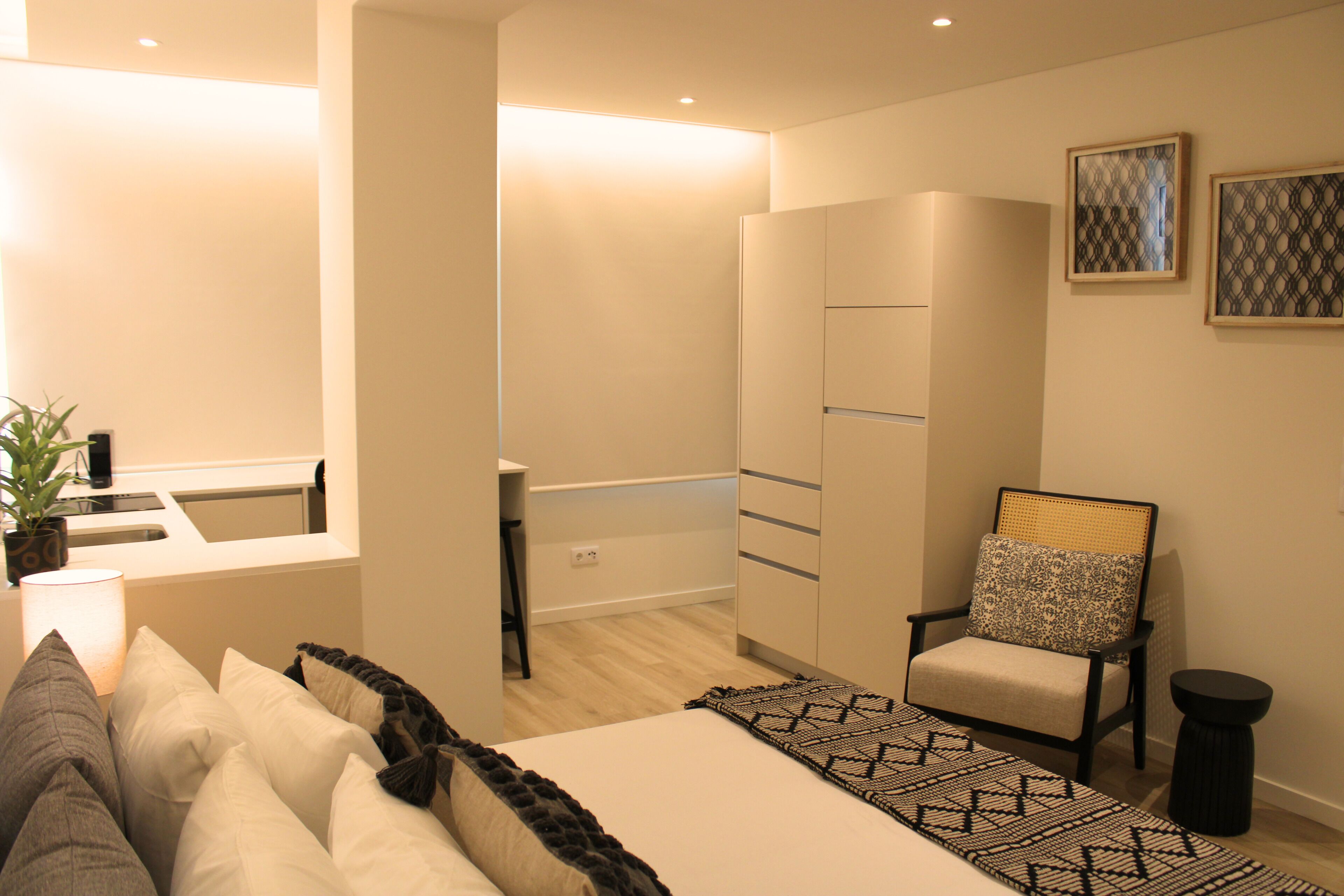 Une chambre à coucher moderne avec un lit, une chaise, un bureau et une armoire.