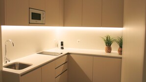 A modern kitchen with a built-in microwave, a sink, and a coffee maker.