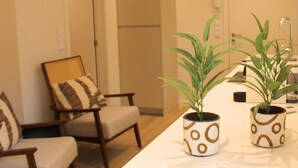 A modern living room with two armchairs, a white coffee table, and two potted plants. - ma-la studios Guimarães 101 (Guimarães)