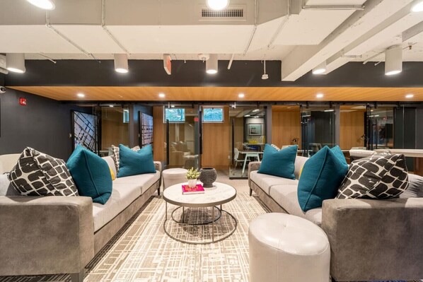 A modern lounge area with sofas and a coffee table, featuring a cityscape floor design.