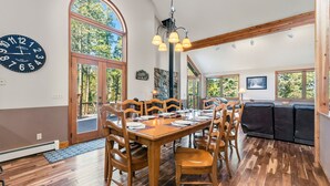 A dining area with a wooden table set for six, surrounded by wooden chairs. - Breckenridge Basecamp | Hot Tub + Fire Pit (Breckenridge)