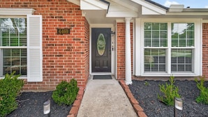 A brick house with a black front door, white shutters, and a number 4469 sign. - Nasa Entertainment Escape: Games, Lazy River Pool (Seabrook)