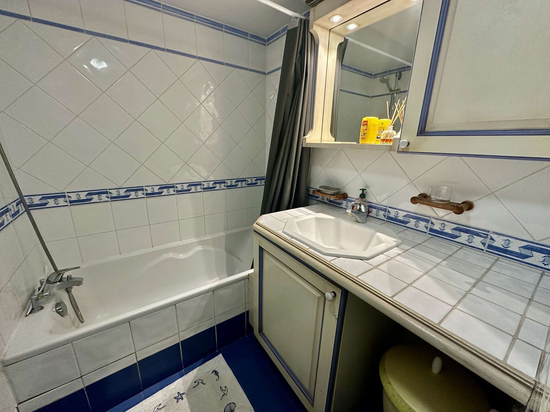 Een badkamer met een bad, wastafel en spiegel.