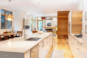 A modern kitchen with a central island, stainless steel appliances, and a wooden accent wall.