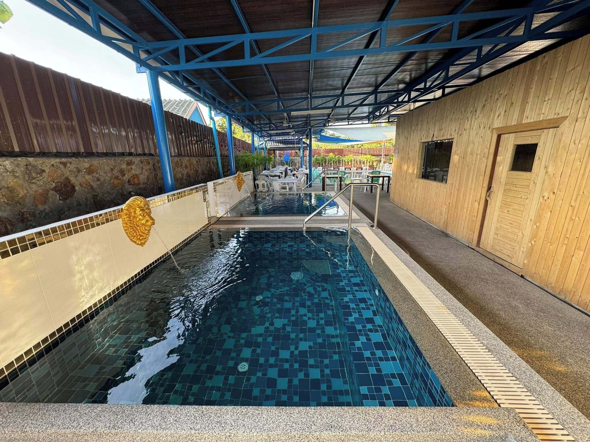 A swimming pool with a tiled floor and a blue ceiling structure.