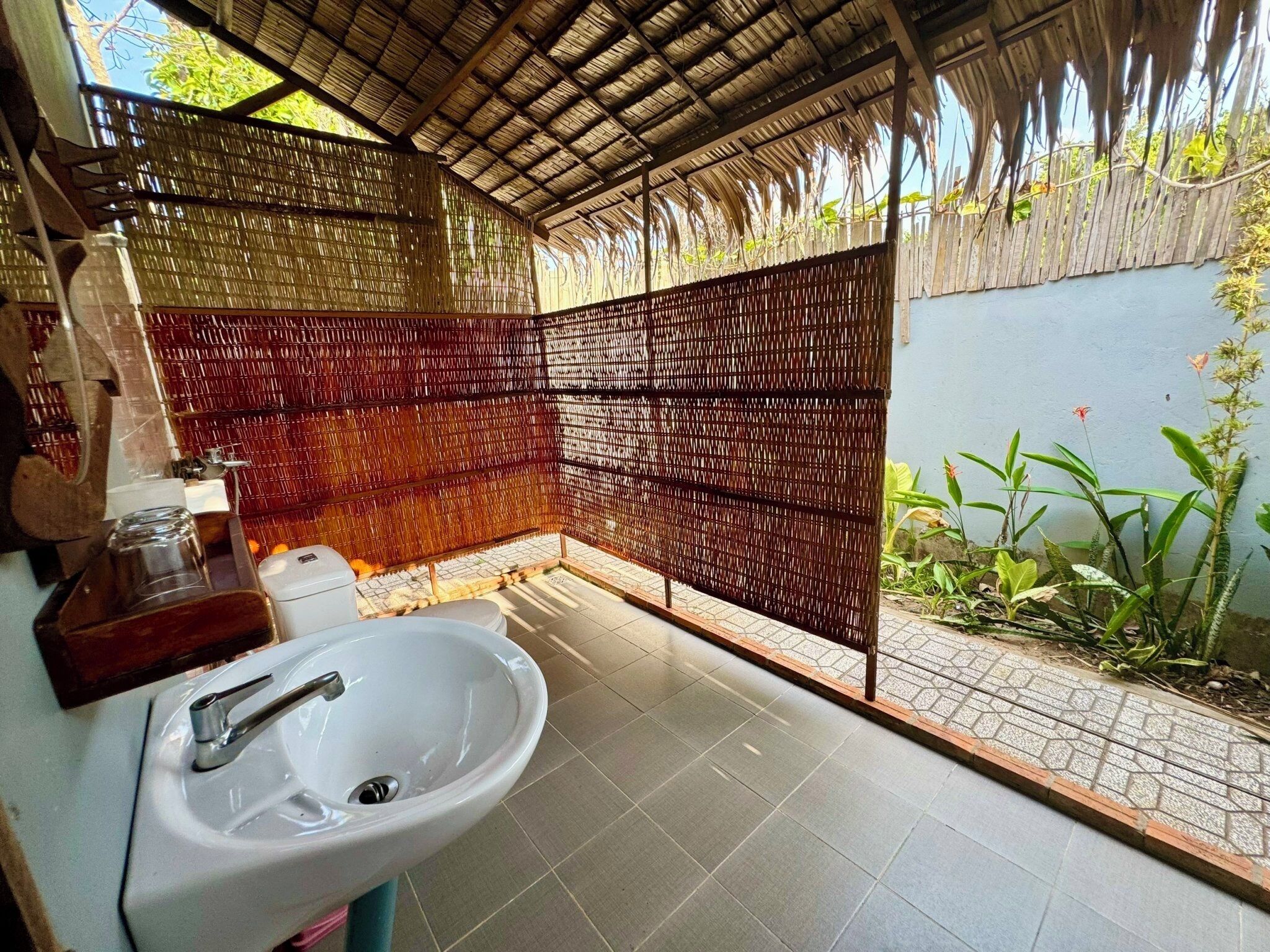 A bathroom with a white sink, a mirror, and a shower area.
