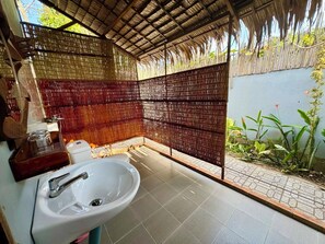 Un bagno con un lavandino bianco, uno specchio e una zona doccia.