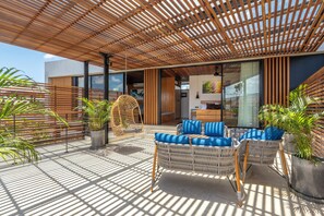 A modern outdoor seating area with wicker furniture and potted plants.