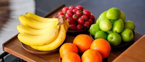 A tray with bananas, cherries, oranges, and green apples.