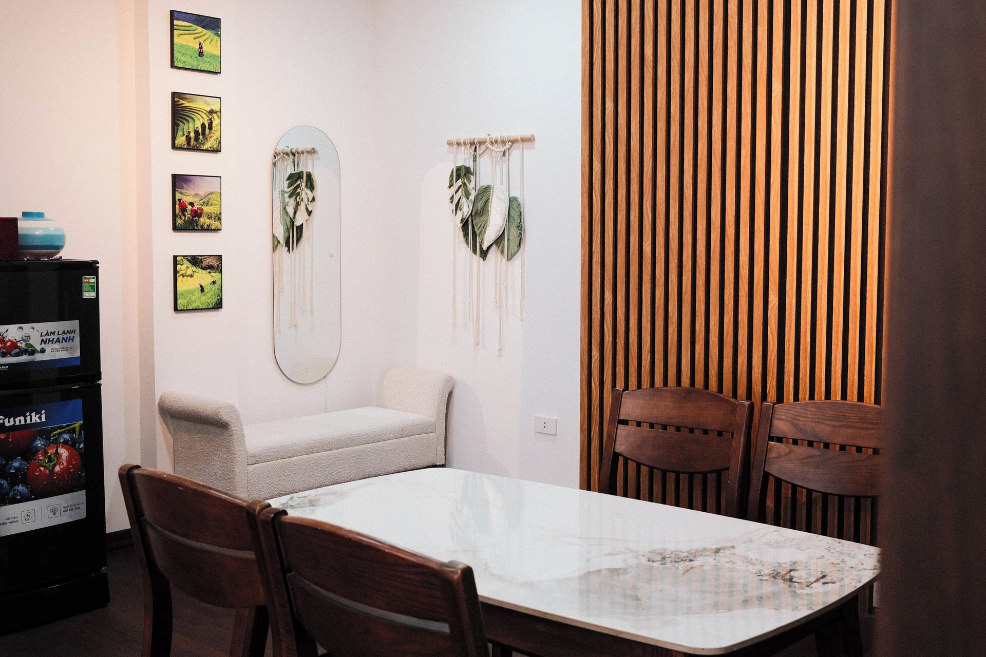 A dining area with a table, chairs, a sofa, and wall decorations.