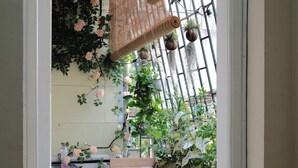 A narrow balcony with a wooden railing, a washing machine, and a small stool. - Home. Homestay (Hanoi)