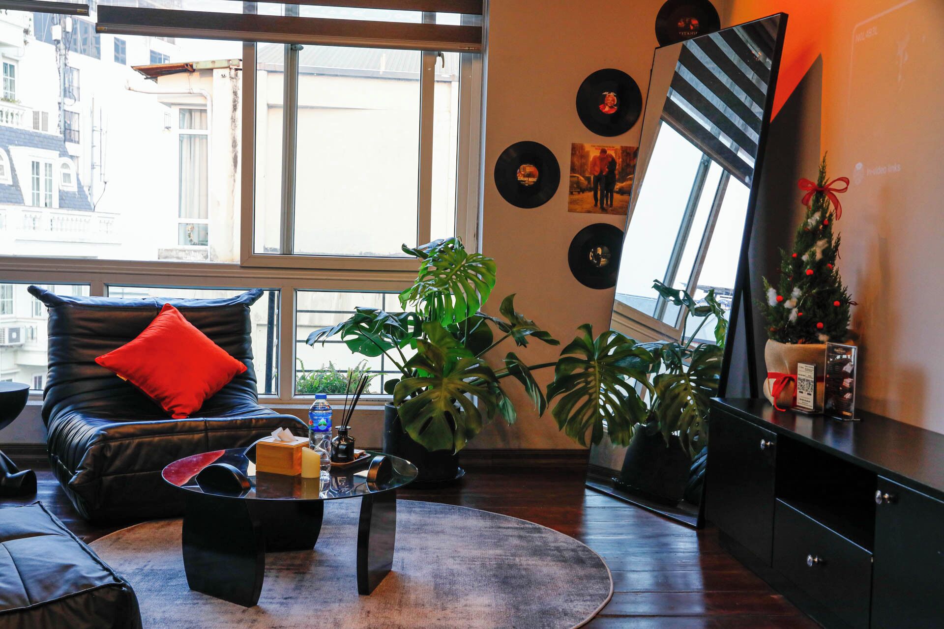 Ein modernes Wohnzimmer mit einer Ledersofa, einem Glastisch und einem großen Fenster.