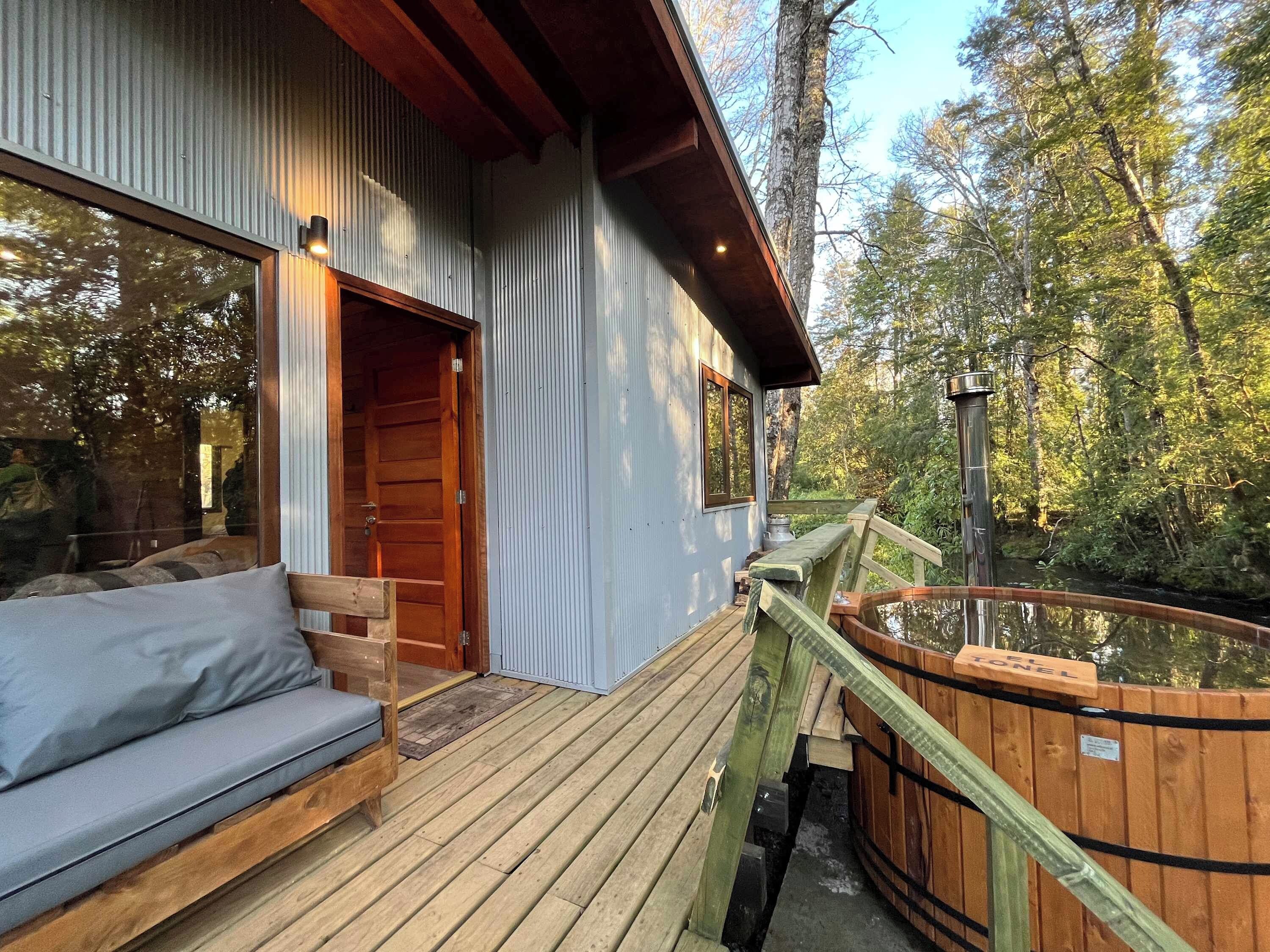 A wooden deck with a bench and a hot tub.