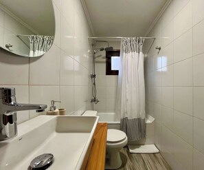 A bathroom with a bathtub, toilet, and shower.