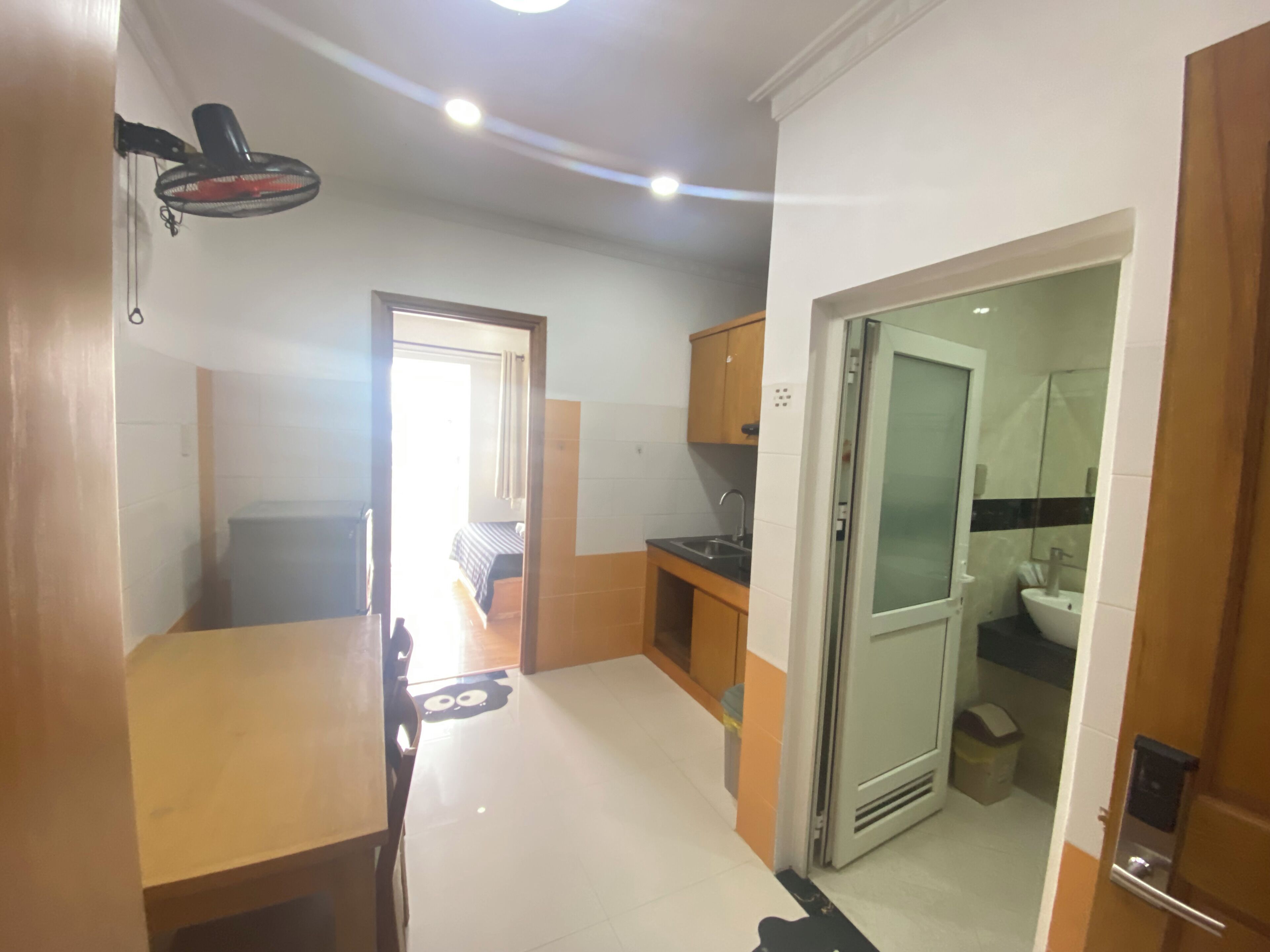 A compact kitchen with a sink, a small countertop, and a ceiling fan.