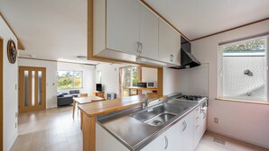 Une cuisine moderne dotée d’un îlot central, d’appareils électroménagers en acier inoxydable et donnant sur l’espace de vie.