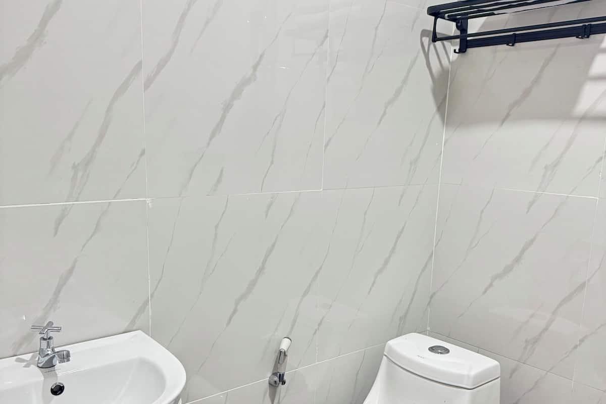 A bathroom with a white sink, toilet, and a towel rack.