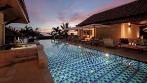 A pool area with a tiled floor, lounge chairs, and a stone wall. -  Katamanda Villa Allegra 5BR Seaview villa Kata (Karon)