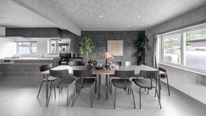 A modern kitchen with a central island, built-in appliances, and a large window providing natural light. - THE ARKLUNE (Sapporo)