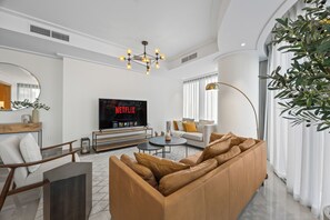 Departamento Deluxe, vista a la ciudad | Sala de estar | Televisión de pantalla plana 